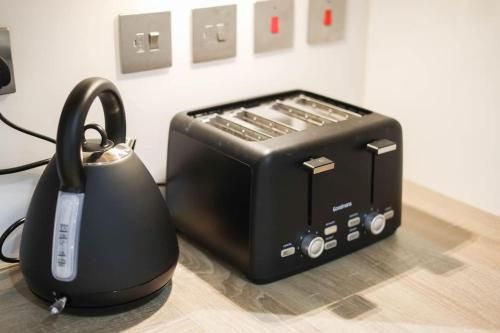 a toaster sitting next to a toaster with a telephone at City Centre, Spacious, Ensuite, Smart TV, Sofa Bed in Bristol