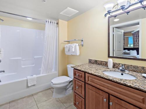 a bathroom with a sink and a toilet and a tub at Tilghman Beach and Golf Resort in Myrtle Beach