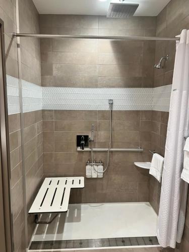 a bathroom with a bench and a shower at Wyndham Garden Redwood Valley in Redwood Valley