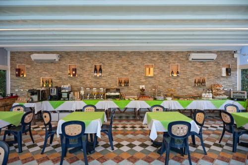 een eetkamer met tafels en stoelen en een bakstenen muur bij Villa Corte Degli Dei in Lucca