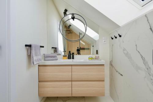 a bathroom with a sink and a mirror at Kalwa Lake House - dom nad jeziorem z prywatnym pomostem i jacuzzi oraz sprzętem wodnym in Pasym