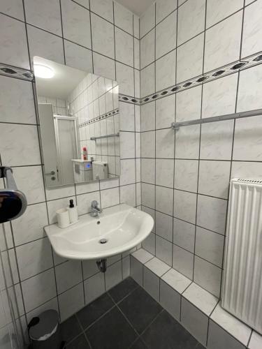 a white bathroom with a sink and a mirror at City Apartment am Rhein Bonn in Bonn