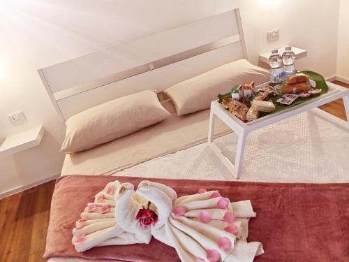 Habitación con cama y mesa con colcha blanca en DIMORA PIETRAMORE, en Brindisi