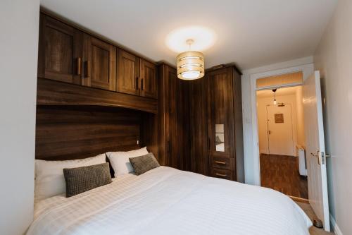 a bedroom with a large white bed with a wooden headboard at Smithfield square Nest in Dublin