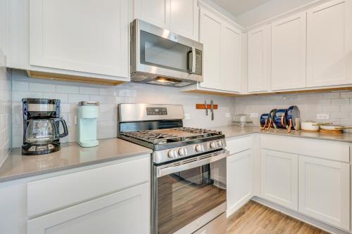 a white kitchen with a stove and a microwave at 12 Mi to Dtwn Austin Quiet Home with Patio and Yard in Austin
