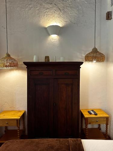 a wooden cabinet in a room with two tables at Casa Gaitana - Alma Hotels in Santa Marta