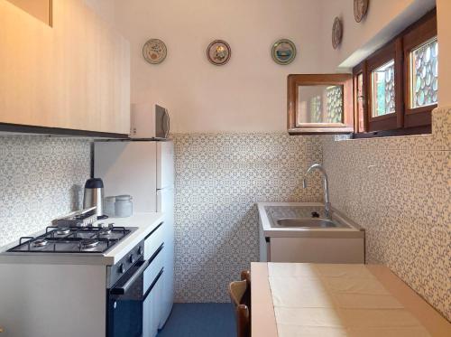 uma pequena cozinha com um fogão e um lavatório em IRIS - Relaxing Alpine Getaway at Ballabio em Ballabio