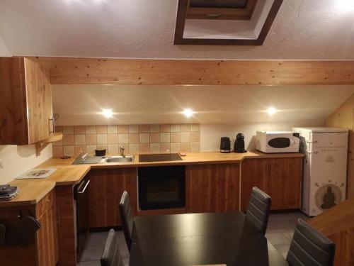 uma pequena cozinha com uma mesa e um micro-ondas em Appartement à la montagne em Villar-dʼArène