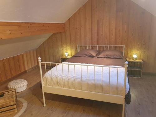 Cama en habitación con paredes y suelo de madera en Appartement à la montagne en Villar-dʼArène