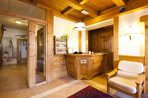a bathroom with a sink and a chair in a room at Hotel Bellaria - Cortina d'Ampezzo in Cortina dʼAmpezzo