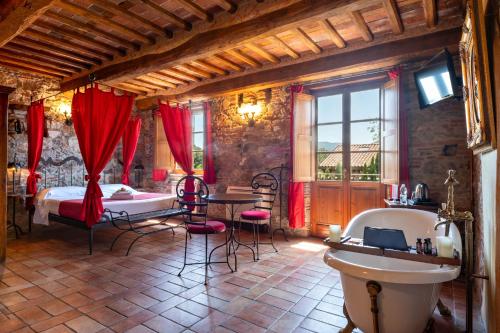a bedroom with a tub and a bed and a sink at Villa Corte Degli Dei in Lucca