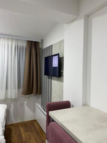 um quarto de hotel com uma televisão na parede em President Kopaonik Apartman l/ll 