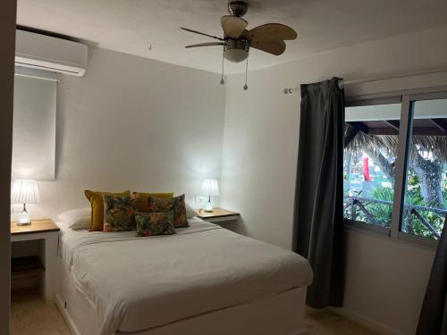 a bedroom with a bed with a ceiling fan and a window at Casa Grande Hotel Restaurant in Las Terrenas
