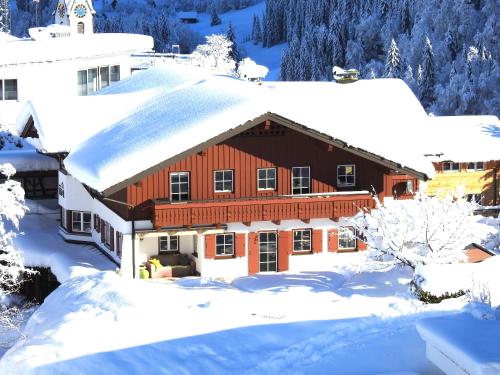 a house covered in snow with snow covered trees at Haus Berg & Tal in Hirschegg
