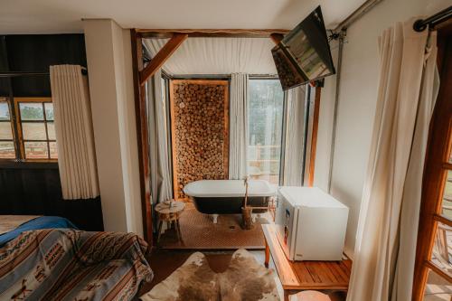 a bathroom with a bath tub and a tv in it at Pousada Campeira in Brotas