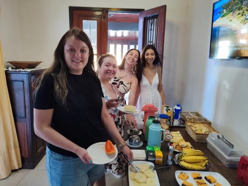 a group of women standing in a kitchen preparing food at Pousada L'étage in Búzios