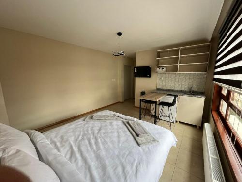 1 Schlafzimmer mit einem weißen Bett und einer Küche in der Unterkunft BROWN in Ankara