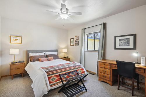 ein Schlafzimmer mit Bett, Schreibtisch und Fenster in der Unterkunft Single Tree Cottage - Walk to Downtown Chama! in Chama