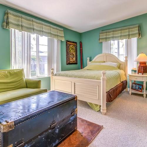 a bedroom with a bed and a chair and a suitcase at Lyons Landing in Islamorada