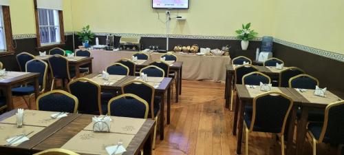 un comedor con mesas y sillas en una habitación en Gran Casona Hostal, en Iquique