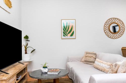 a living room with a couch and a table at Light Filled Modern Specious Home, Pet friendly in a beautiful area of Byron Bay, short stroll to town in Byron Bay