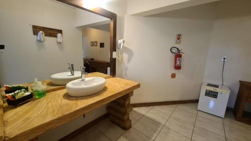 uma casa de banho com 2 lavatórios num balcão de madeira em Sítio Costão da Fortaleza - Canyons do Brasil em Praia Grande