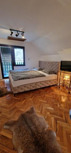 a bedroom with a large bed on a wooden floor at Holiday Home Oaza Mira in Visoko