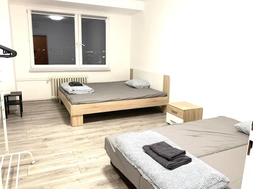 1 Schlafzimmer mit 2 Betten und einem Fenster in der Unterkunft Útulný apartmán nedaleko centra in Mariánské Hory