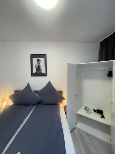 a bedroom with a bed and a cat sitting on a shelf at City Apartment am Rhein Bonn in Bonn
