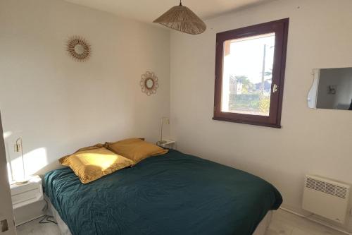 une chambre avec un lit vert et une fenêtre dans l'établissement Pretty Norman nest 2 steps from the sea, à Ouistreham