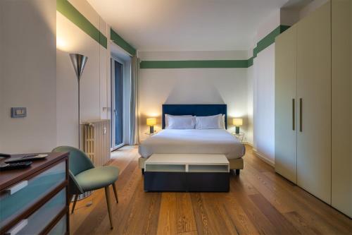 a hotel room with a bed and a desk and chair at Santa Sofia Home in Milan