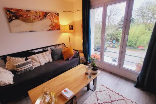 uma sala de estar com um sofá preto e uma mesa de centro em Pretty haven of peace with terrace em Avignon