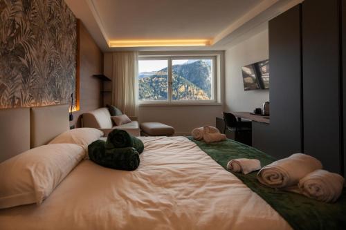 1 dormitorio con 1 cama grande y toallas. en Il Quadrifoglio - alloggio turistico, en Valle di Cadore