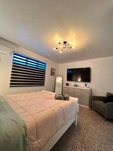 um quarto com uma cama e uma televisão de ecrã plano em Playa y Campo Apartment #2 em Isabela