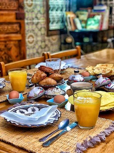 a wooden table with eggs and drinks on it at Riad Dwiriyat My Teib in Marrakech