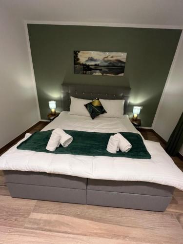 ein Schlafzimmer mit einem großen Bett und Hausschuhen darauf in der Unterkunft UNiQE I 95qm I Bergblick I Garten I BBQ I seenah in Prien am Chiemsee