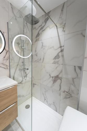 uma casa de banho com chuveiro e mármore branco em Magnifique Studio à Beaulieu-sur-mer em Beaulieu-sur-Mer