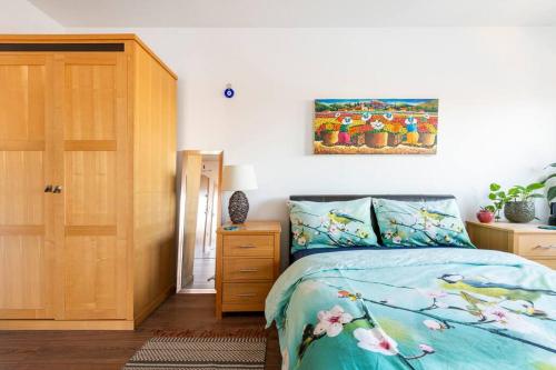 1 dormitorio con 1 cama y una pintura en la pared en London Skylineviews 2 bed 2 bath flat near Canary Wharf, o2 & Excel en Londres