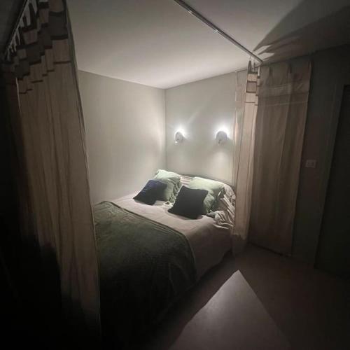 een kleine slaapkamer met een bed met 2 kussens bij Studio indépendant entre lac et montagne in Seynod