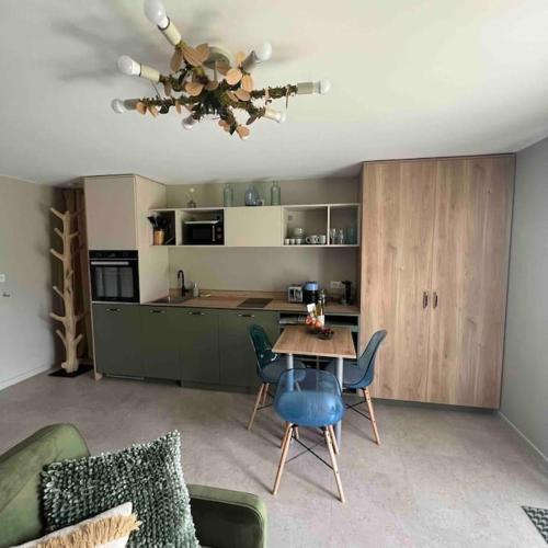 een woonkamer met een tafel en een keuken bij Studio indépendant entre lac et montagne in Seynod