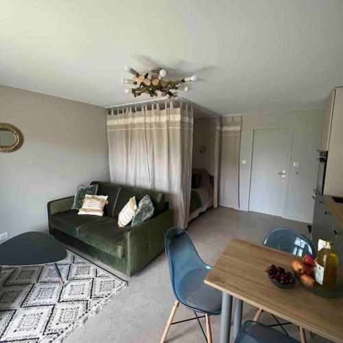 een woonkamer met een bank, stoelen en een tafel bij Studio indépendant entre lac et montagne in Seynod