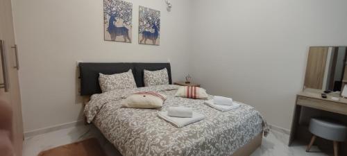 ein Schlafzimmer mit einem Bett mit zwei Handtüchern darauf in der Unterkunft City Hall studio apartment in Tríkala
