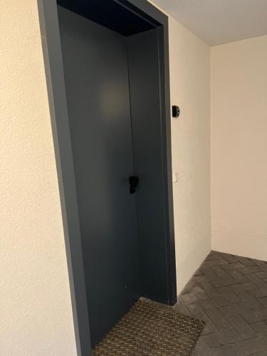a black door in the corner of a room at Suite One Einsteinstraße in Munich