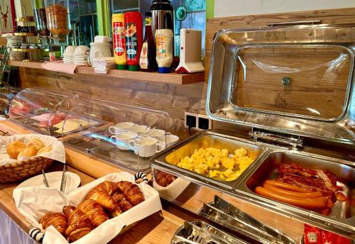 a buffet with many trays of food and pastries at Hotel Bergland in Grainau