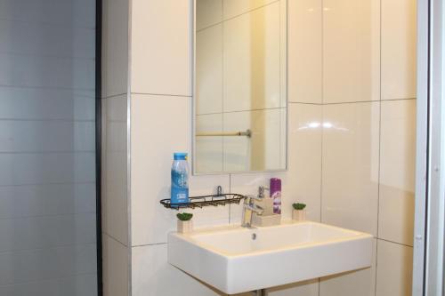a bathroom with a white sink and a mirror at Cozy Retreat in Windhoek in Windhoek