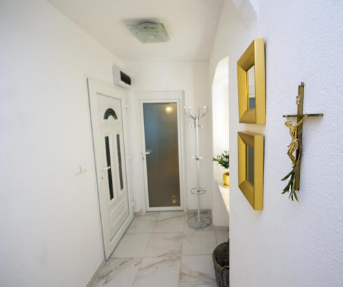 um corredor com paredes brancas, uma porta e um piso de azulejo em Apartment Dea em Split