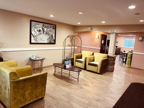 a waiting room with yellow chairs and a table at FairBridge Inn Express Nyack in Nyack