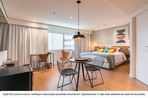 um quarto com uma cama, uma mesa e cadeiras em Cyclinn Vila Olímpia em São Paulo