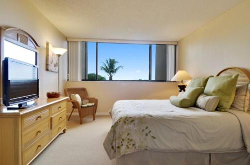 een slaapkamer met een groot bed en een groot raam bij Moon Bay A410 in Key Largo