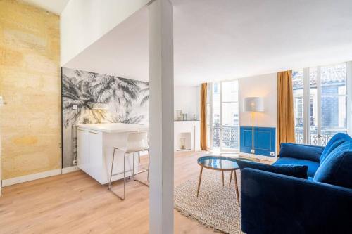 - un salon avec un canapé bleu et une table dans l'établissement Appartement entier haut de gamme, à Bordeaux